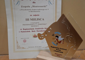 Zdjęcie dyplomu i złotej statuetki.