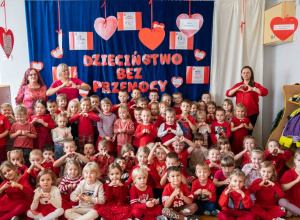 Zdjęcie grupowe dzieci z nauczycielami. Wszyscy ubrani na czerwono.