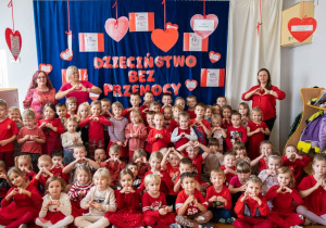 Zdjęcie grupowe dzieci z nauczycielami. Wszyscy ubrani na czerwono.