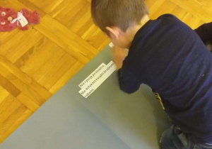 Dzieci naklejają na kartce zasady postępowania z książką.