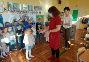 Pasowanie dziewczynki przez panią dyrektor.