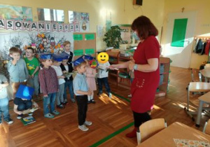 Pani dyrektor pasuje chłopca na Montessorka.