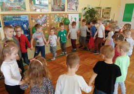 Dzieci tańczą w kole.