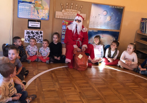 Dzieci słuchają Mikołaja.