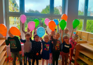 Dzieci trzymają balony.