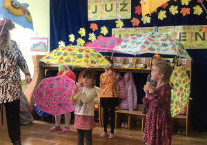 Dzieci tańczą z parasolkami.