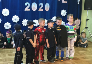 Sześciu chłopców stoi na środku sali.
