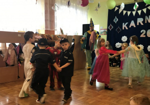 Dzieci tańczą w dwóch kółeczkach.