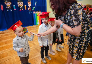 Pani Dyrektor pasuje chłopca na montessorka.