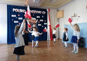 Dziewczynki tańczą z flagami.