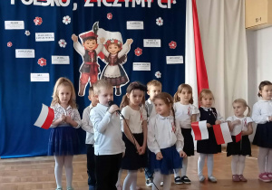 Dzieci ubrane w stroje galowe recytują wierszyki o tematyce narodowej.