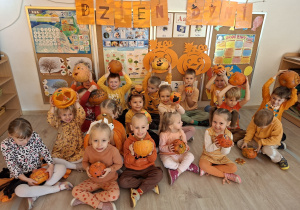 Dzieci z grupy I pozują do wspólnego zdjęcia. Dzieci ubrane w pomarańczowe stroje.