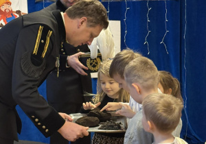 Dzieci oglądają przyniesiony przez Górników węgiel.