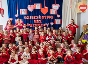 Zdjęcie grupowe dzieci z nauczycielami. Wszyscy ubrani na czerwono.