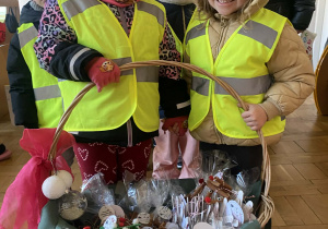 Dwie dziewczynki z koszem świątecznych upominków.