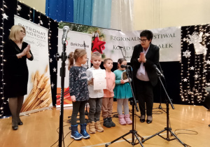 Dzieci odbierają statuetkę i dyplom.