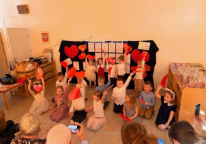 Dzieci z grupy I śpiewają z serduszkami w dłoniach.