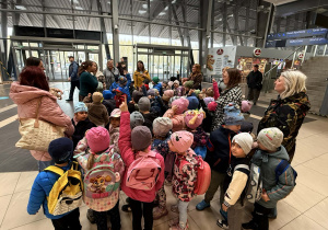 Zdjęcie dzieci i nauczycieli słuchających pani przewodnik.