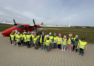 Zdjęcie dzieci z grupy II i IV obok samolotu.