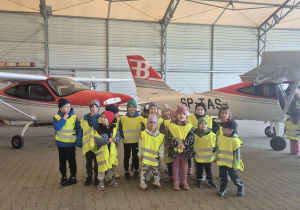 Zdjęcie dzieci z grupy I obok samolotu.