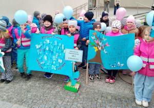 Zdjęcie dzieci z banerami dotyczącymi obchodów Światowego Dnia Świadomości Autyzmu.