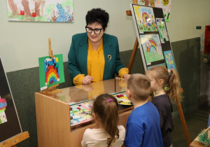 Pani prezydent ogląda prace wraz z dziećmi.