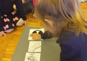 Dzieci naklejają na kartce regulamin małego czytelnika.