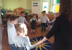 Dzieci tańczą z nauczycielką.