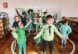 Dzieci tańczą z zielonymi wstążkami