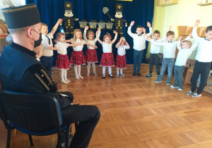 Dzieci śpiewaią piosenkę trzymając się za ręce.