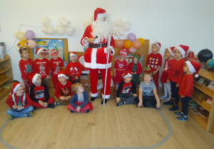 Mikołaj stoi wśród dzieci.
