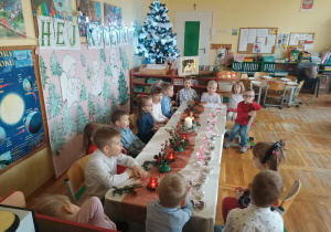 Dzieci siedzą przy świątecznym stole.