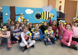 Dzieci na tle makiety z pszczołą.