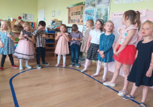 Dzieci stoją i śpiewają piosenkę.